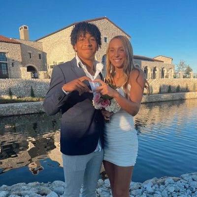 Peyton Bowen and Emma Alvord are using their hands to make a complete heart sign.